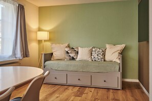 Een kamer met een bed, een tafel en een lamp.