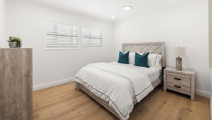 A bedroom with a bed, bedside tables, a nightstand, a potted plant, and a window with blinds. - 2 Bedroom 1 Block From the Sand Manhattan Beach (Manhattan Beach)
