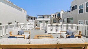 A rooftop patio with wooden furniture and white railings. - 2 Bedroom 1 Block From the Sand Manhattan Beach (Manhattan Beach)
