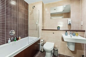 A bathroom with a bathtub, toilet, sink, and mirror. - Luxury 2BR | Baltic Triangle & Sefton Park (Merseyside)