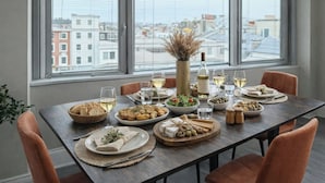Una mesa de comedor dispuesta con diferentes platos, vasos y un florero con plantas secas.