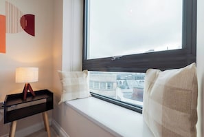 A room with a window seat, a lamp, and a wall art piece. - Luxury 3BR Brighton Centre | City Views | Sleeps 9 (Brighton and Hove)