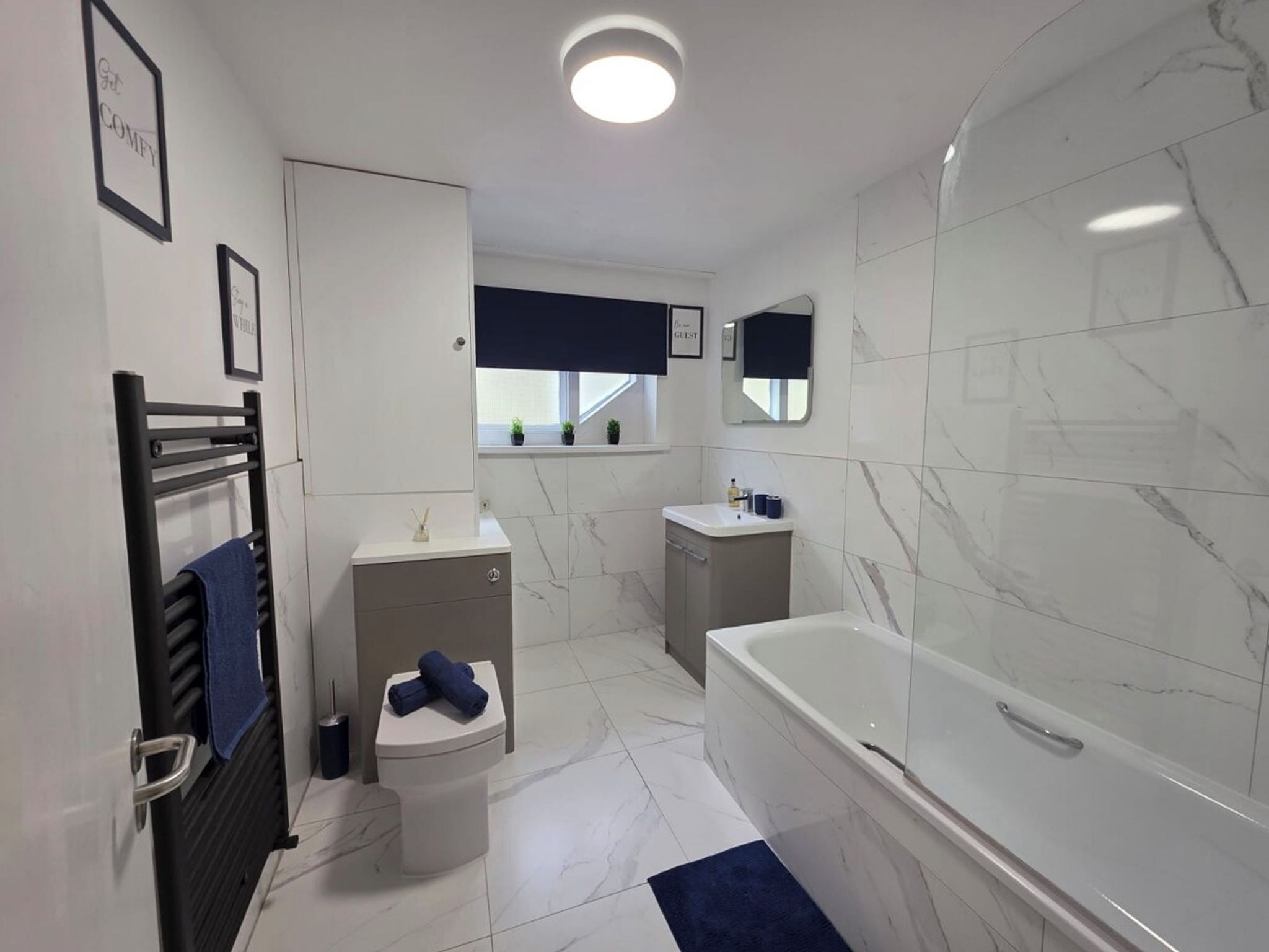 Un baño moderno con bañera, inodoro, lavamanos y toallero.