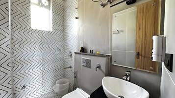 Een douche, handdoeken, zeep, toiletpapier