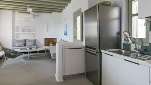 Eine moderne Küche mit Edelstahl-Kühlschrank, weißen Schränken und einer eingebauten Spüle.