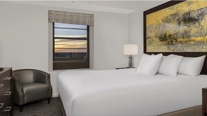 A hotel room with a large bed, a chair, a desk, a lamp, a painting, and a window with a view. - Spacious 3-bedroom Wyndham condo on the Atlantic  inDaytona Beach. (Daytona Beach)
