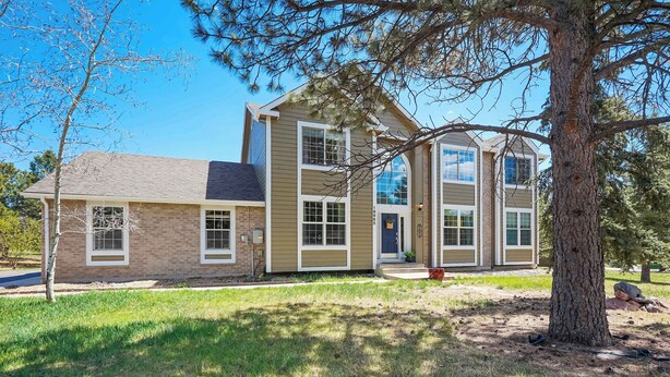A two-story house with a brick facade, large windows, and a front porch. - Ridgemont Hall! Grand Mountain Home w/ Peak Views (Monument)