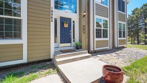 A two-story house with a front porch, a mailbox, and a number '19965' on the wall. - Ridgemont Hall! Grand Mountain Home w/ Peak Views (Monument)
