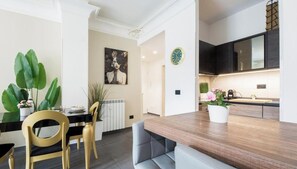Eine moderne Küche mit dunklen Schränken, einer Holzarbeitsplatte und einer Uhr an der Wand.