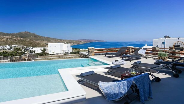 A pool with lounge chairs and a view of the sea. - Kalafatis Stay With Private Pool (Mykonos)