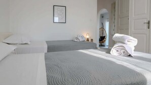 A hotel room with two beds, a framed picture on the wall, and a door leading to another room. - Kalafatis Stay With Private Pool (Mykonos)