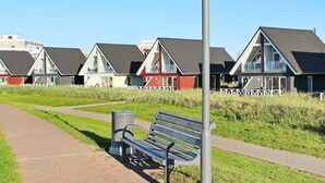 A row of beach houses with a pathway and a bench. - 6 Person Holiday Park Home in Wendtorf (Wendtorf)