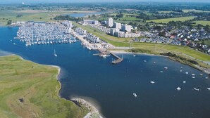 An aerial view of a marina with boats docked, a pier, and surrounding residential buildings. - 6 Person Holiday Park Home in Wendtorf (Wendtorf)