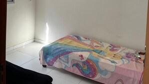 A bedroom with a bed, a window, and a door.