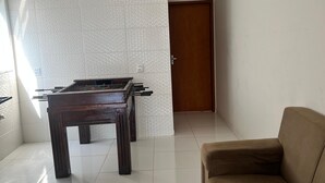 A room with a pool table, a sofa, and a door.