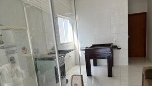 A kitchen with a stove, oven, and a foosball table.