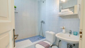 Ein Badezimmer mit Dusche, Toilette, Waschbecken und Handtuchhalter.