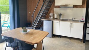 A compact kitchen with a wooden table, chairs, a coffee maker, and a sink. - LE FAUCON PELERIN - TOURNAVAUX (TOURNAVAUX)