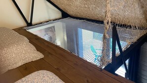 A loft-style bedroom with a sloped ceiling, a hammock, and a view of the outdoors. - LE FAUCON PELERIN - TOURNAVAUX (TOURNAVAUX)