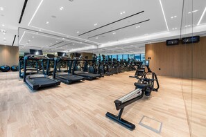 Ein modernes Fitnessstudio mit Laufbändern, Crosstrainern und Übungsbällen.