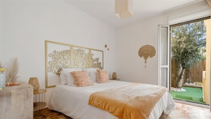 A bedroom with a large bed, a view of the outdoors, and a decorative wall piece. - Carry Le Rouet, Proche Plages, Commerces (Carry-le-Rouet)