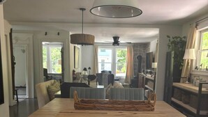 A kitchen with a wooden island, white cabinetry, and a hanging pendant light. - The Outdoor Inn (Lenoir)