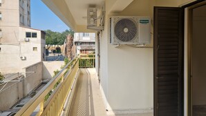 A balcony with a view of a building, an air conditioning unit, and a door. - Urban Nest Central Nicosia Spacious 2BR Apartment (Nicosia)