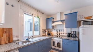 Eine moderne Küche mit Granit Arbeitsplatte, Edelstahlspüle und eingebautem Backofen.
