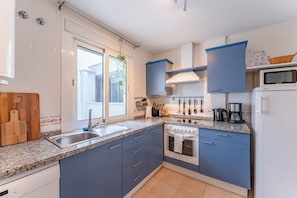 A modern kitchen with a granite countertop, stainless steel sink, and a built-in oven. - 3 Bed with Panoramic Sea views - Pass the Keys (Fuengirola)