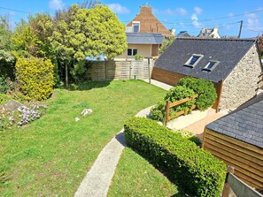 A residential property with a stone house, a paved pathway, and a well-maintained garden. - Breton Stone Cottage by Sandy Beaches (Landeda)