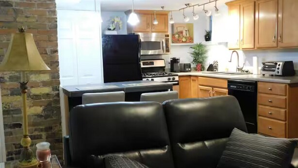 Une cuisine moderne équipée d’une cuisinière, d’un four à micro-ondes et d’un four traditionnel. On y trouve également un coin repas avec une table et des chaises.