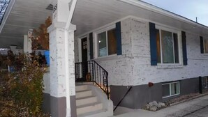 Une maison à deux étages avec un porche, un escalier et un garage.