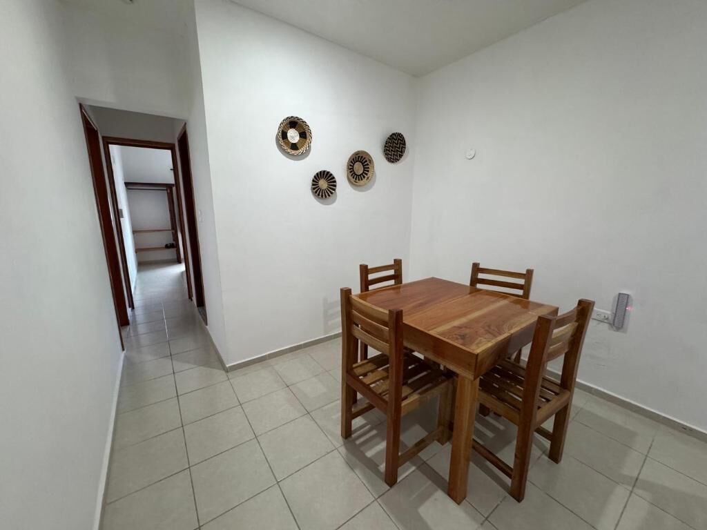 A dining area with a wooden table and chairs, a hallway, and decorative wall plates.