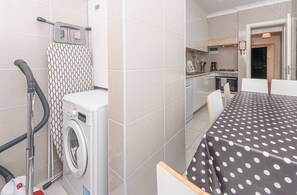 Eine kleine Küche mit Herd, Spüle und einem Essbereich mit Tisch und Stühlen.