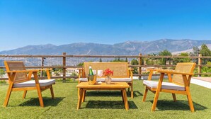 An outdoor seating area with a table, chairs, and a view of mountains. - La Bailonga Cómpeta by Ruralidays (Málaga)