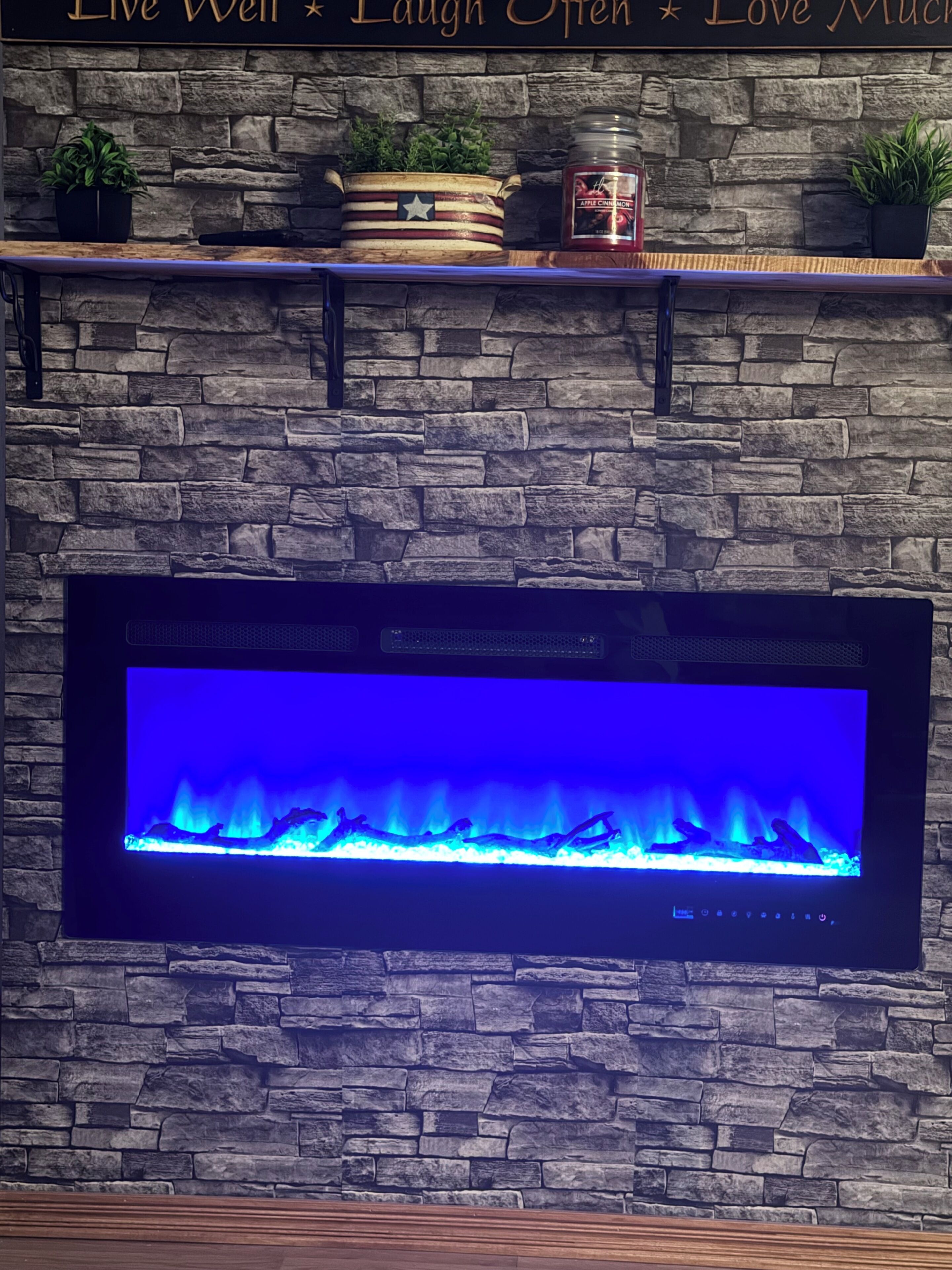 Pared de piedra con un televisor de pantalla plana montado sobre una chimenea.