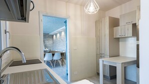 Una cocina moderna con estufa integrada, un fregadero y una zona de comedor con sillas.