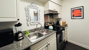 A compact kitchen with a sink, stove, microwave, and a blender. - The Hidden Gem of Dallas (Dallas)