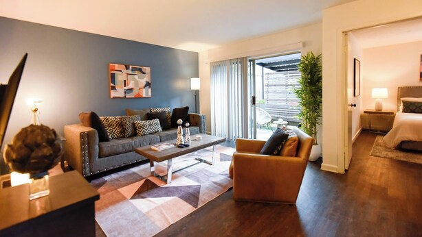 A modern living room with a sofa, armchair, coffee table, and artwork on the wall. - The Hidden Gem of Dallas (Dallas)