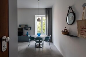 A modern dining area with a round table, chairs, a vase, and a window with curtains. - Azul Balcony near the Cala (PALERMO)