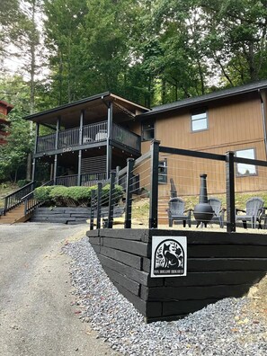 A two-story building with a balcony, a chimney, and outdoor seating. - Fox Hollow Hideaway - Cabin (Gatlinburg)
