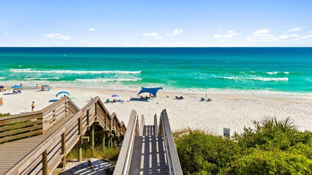 A beach with a wooden boardwalk leading to the shore, clear turquoise water, and a few beach umbrellas. - 🌅 Golden Sun – Stylish 30A Beach Retreat | Walk to Gulf | Sleeps 8 🏖️ (Santa Rosa Beach)