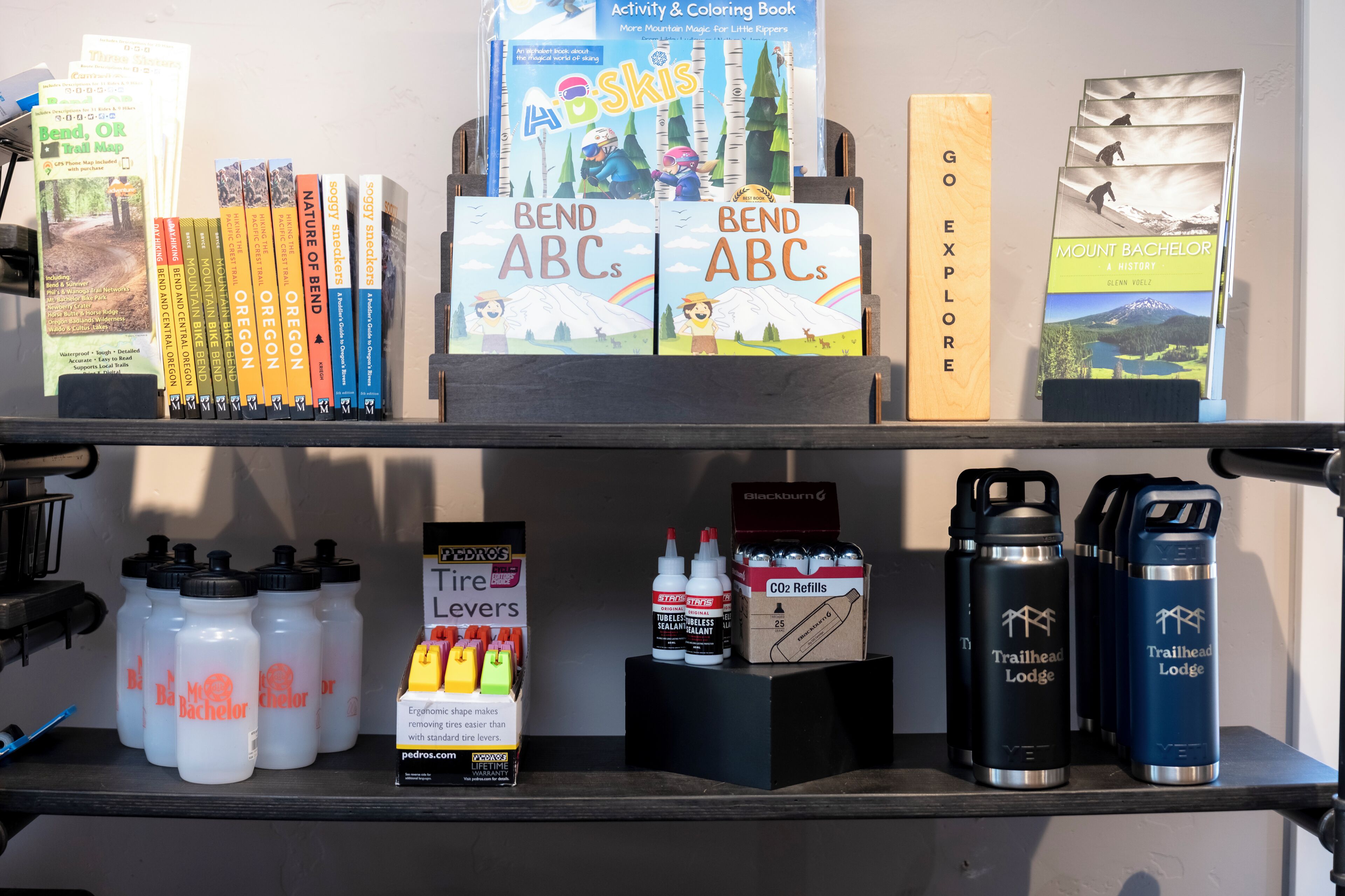 Una estantería con libros, mapas y botellas de agua.