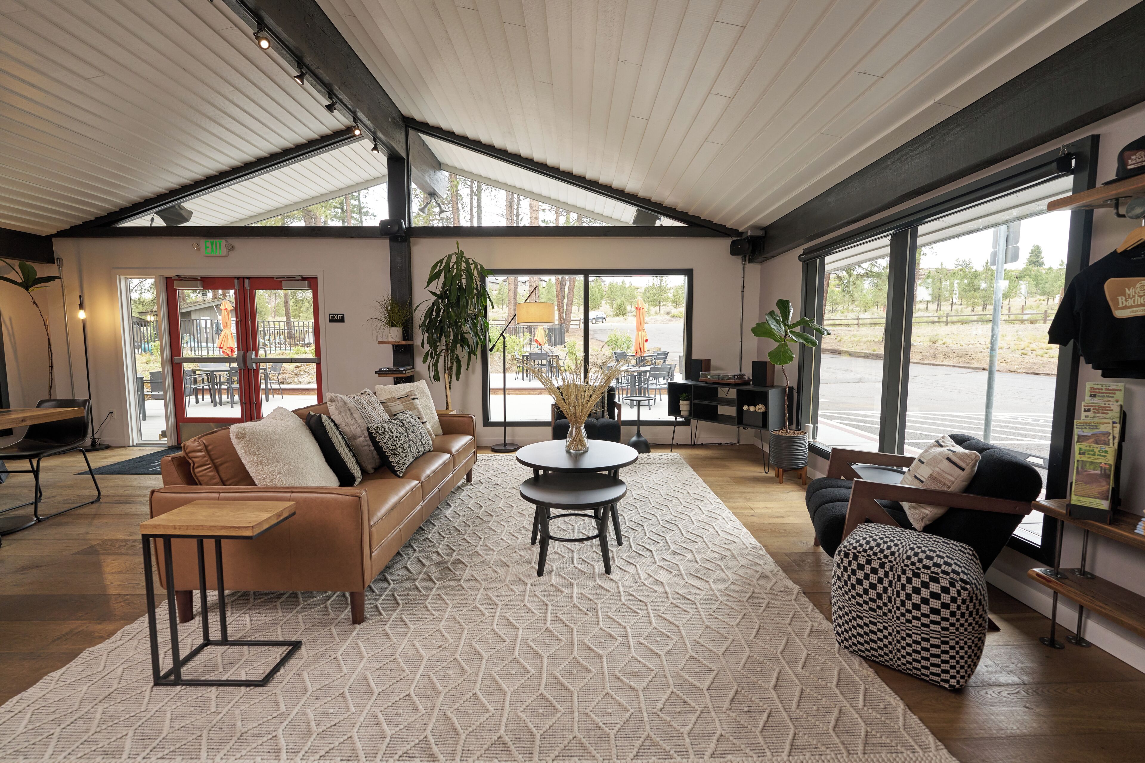 A spacious lobby with a leather sofa, a round table, and a checkered ottoman.
