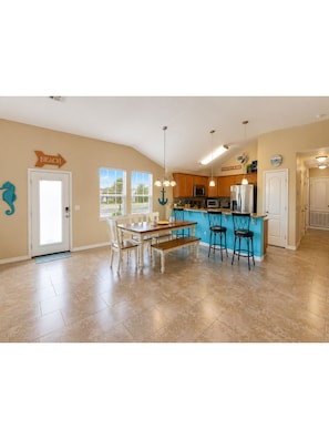 A spacious kitchen with a dining area, a kitchen island, and a view of the outdoors. - Drunken Marlin, Private pool, minutes from the beach, Pet friendly (Port Aransas)