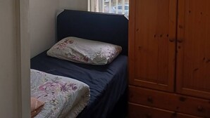 A small room with a bed, a wardrobe, a window with blinds, and a ceiling light fixture. - Room-cosy Single Room Near CBS Arena and (Coventry)