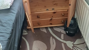 A wooden wardrobe with a single door, a small drawer, and a hanging rod. - Room-cosy Single Room Near CBS Arena and (Coventry)
