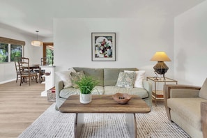 Ein Wohnzimmer mit Sofa, Couchtisch und einem Gemälde an der Wand.