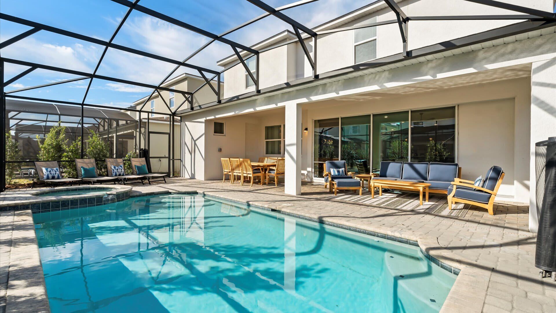 A swimming pool with lounge chairs and a covered patio area.