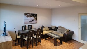 Een moderne woonkamer met een eettafel, stoelen, een bank en een salontafel.